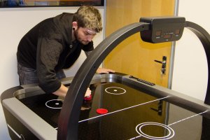 A game of air hockey being played.
