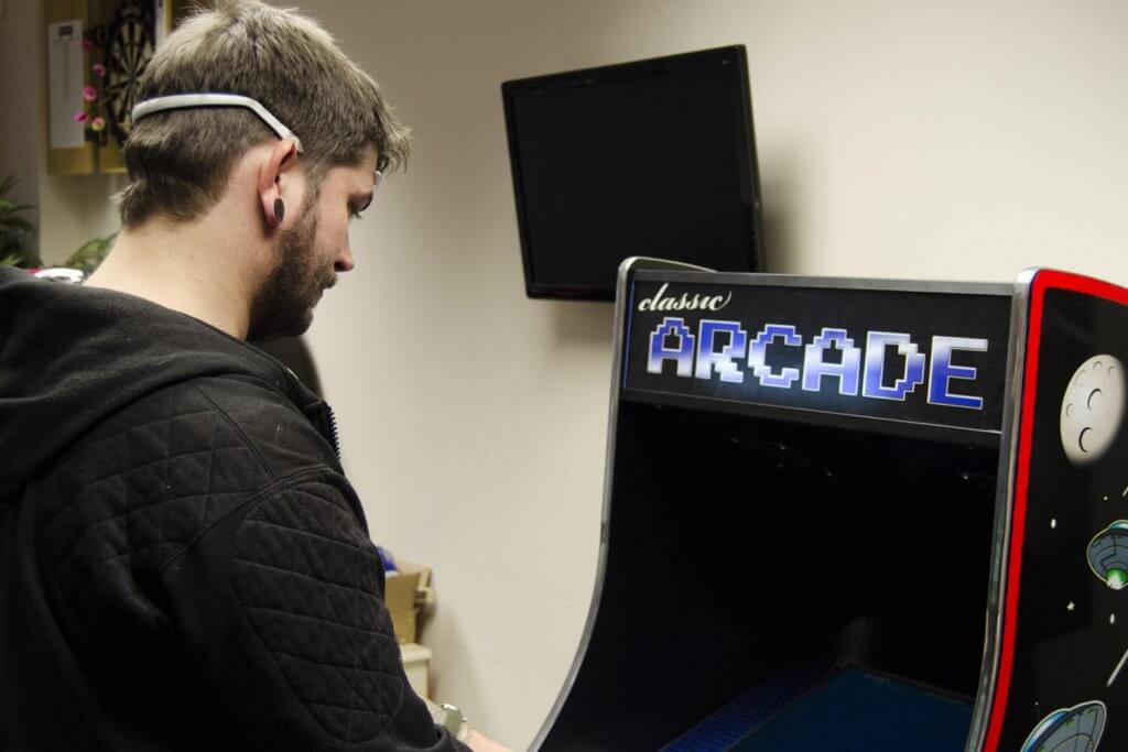 A videogame player wearing a biometric headset for gathering brainwave data
