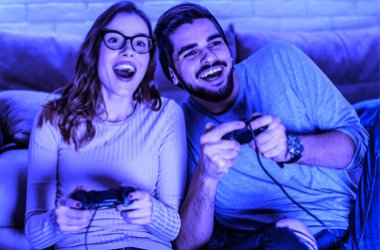 A happy couple playing a video game together.