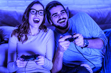 A happy couple playing a video game together.
