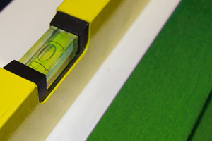 A spirit level being used to level the Olympus pool table