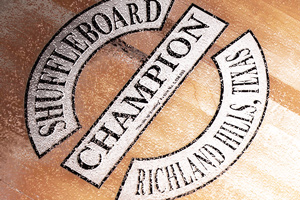 The Champion shuffleboard logo on a table