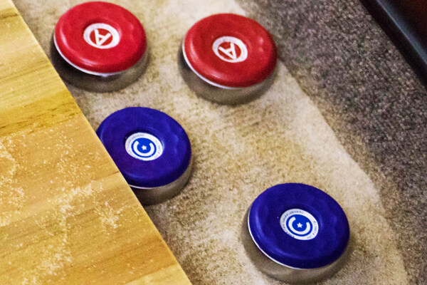 Shuffleboard pucks in a table gutter