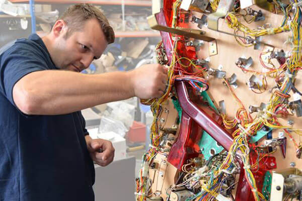 Technician working on pinball machine