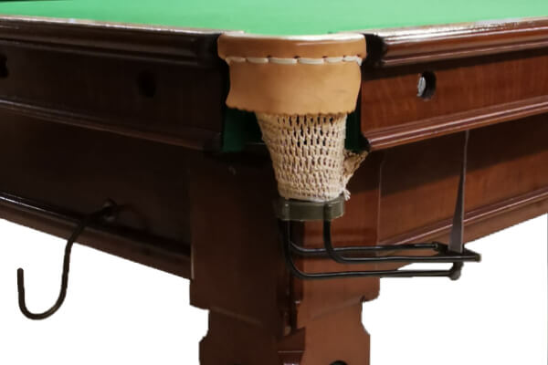 The pocket of a vintage snooker table.