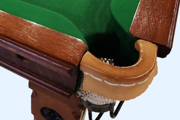 The pocket of a vintage snooker table.