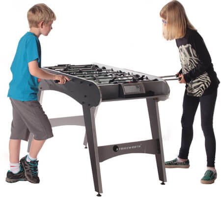 Children playing on a Defender football table.