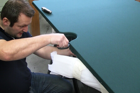Fitting a pool table cloth.