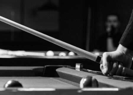 A player holding a cue over a pool table
