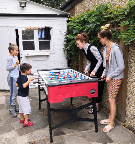 A family playing on an outdoor football table.
