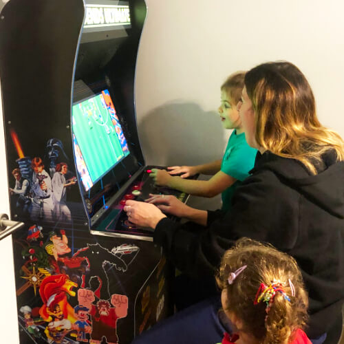 A family playing the AtGames Legends Ultimate arcade machine.