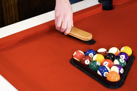 A pool table being brushed.
