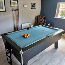 The Blackball slate bed pool table in a room.