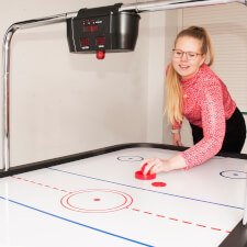 A girl playing Sure Shot Super Pro Air Hockey.