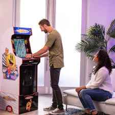 People playing Arcade1up Bandai Namco Pac-Mania legacy arcade machine.