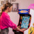 Girl playing Arcade1up Bandai Namco Pac-Mania legacy arcade machine.