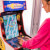Girl playing Arcade1up Bandai Namco Pac-Mania legacy arcade machine.