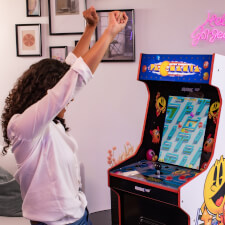 People playing Arcade1up Bandai Namco Pac-Mania legacy arcade machine.