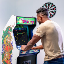 Man playing Arcade1up Atari legacy Centipede arcade.