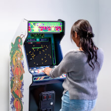 Girl playing Arcade1up Atari legacy Centipede arcade.