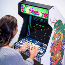 Girl playing Arcade1up Atari legacy Centipede arcade.