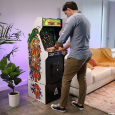 Man playing Arcade1up Atari legacy Centipede arcade machine.