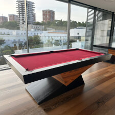 The Meridian slate bed pool table in black matte and red cloth.
