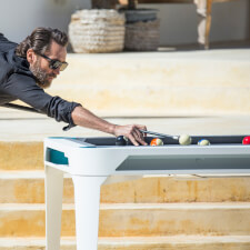 People playing Cornilleau Hyphen Outdoor pool table.
