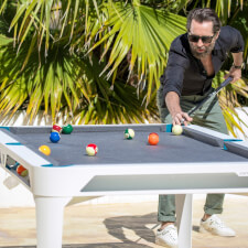 People playing Cornilleau Hyphen Outdoor pool table.