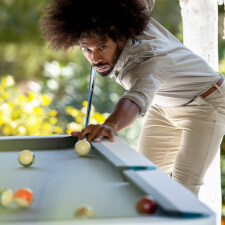 People playing Cornilleau Hyphen Outdoor pool table.