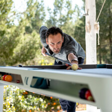 People playing Cornilleau Hyphen Outdoor pool table.