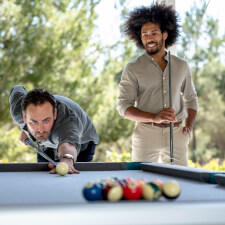 People playing Cornilleau Hyphen Outdoor pool table.