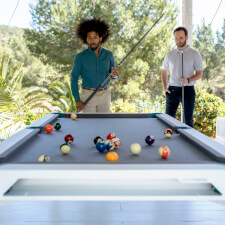 People playing Cornilleau Hyphen Outdoor pool table.