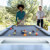 People playing Cornilleau Hyphen Outdoor pool table.