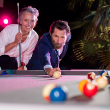 People playing Cornilleau Hyphen Outdoor pool table.