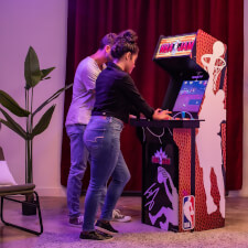 People playing Arcade1Up NBA Jam machine.