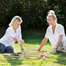 People playing Giant Mikado family game.