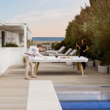 People Playing Diagonal Outdoor Pool Table In White.