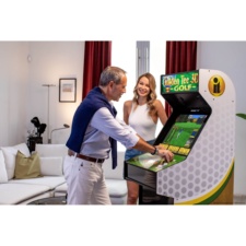 Couple playing Golden Tee arcade machine from the side