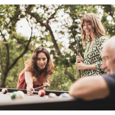 People playing Cornilleau Origin Outdoor Pool Table.