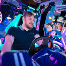 People playing the Sega Apex Rebels arcade machine.