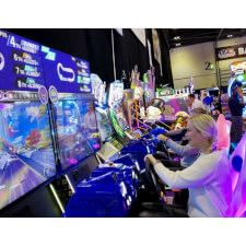 People playing the Sega Apex Rebels arcade machine.