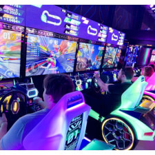 People playing the Sega Apex Rebels arcade machine.