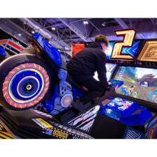 A kid racing the Sega Storm Rider 2 Motion Twin arcade machine.