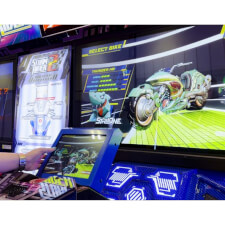 People racing the Sega Storm Rider 2 Motion Twin arcade machine.
