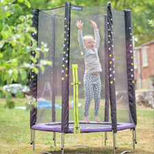 Kid bouncing on the Plum Junior Stardust Springsafe trampoline with enclosure.