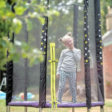 Kid bouncing on the Plum Junior Stardust Springsafe trampoline with enclosure.