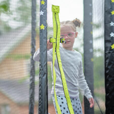 Kid zipping the enclosure of the Plum Junior Stardust Springsafe trampoline.