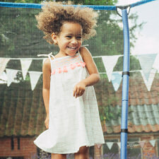 Kid Jumping on the Plum 7ft Junior Springsafe Jumper trampoline with enclosure.
