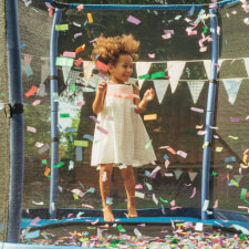 Kid Jumping on the Plum 7ft Junior Springsafe Jumper trampoline with enclosure.